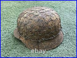 WW2 German combat helmet M35 with an original metal camouflage mesh. Size 65