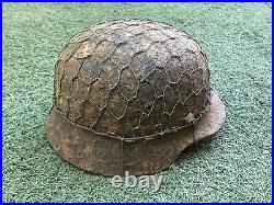WW2 German combat helmet M35 with an original metal camouflage mesh. Size 65